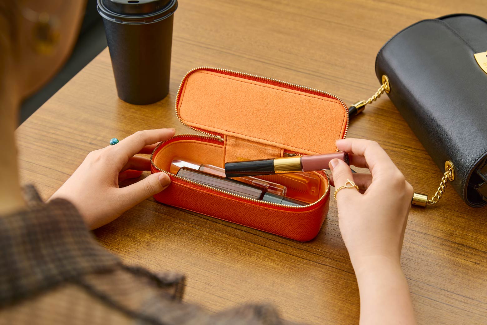 伊東屋　カラーチャート　レザーキューブロングにコスメなどいつも持ち歩くアイテムを入れている様子