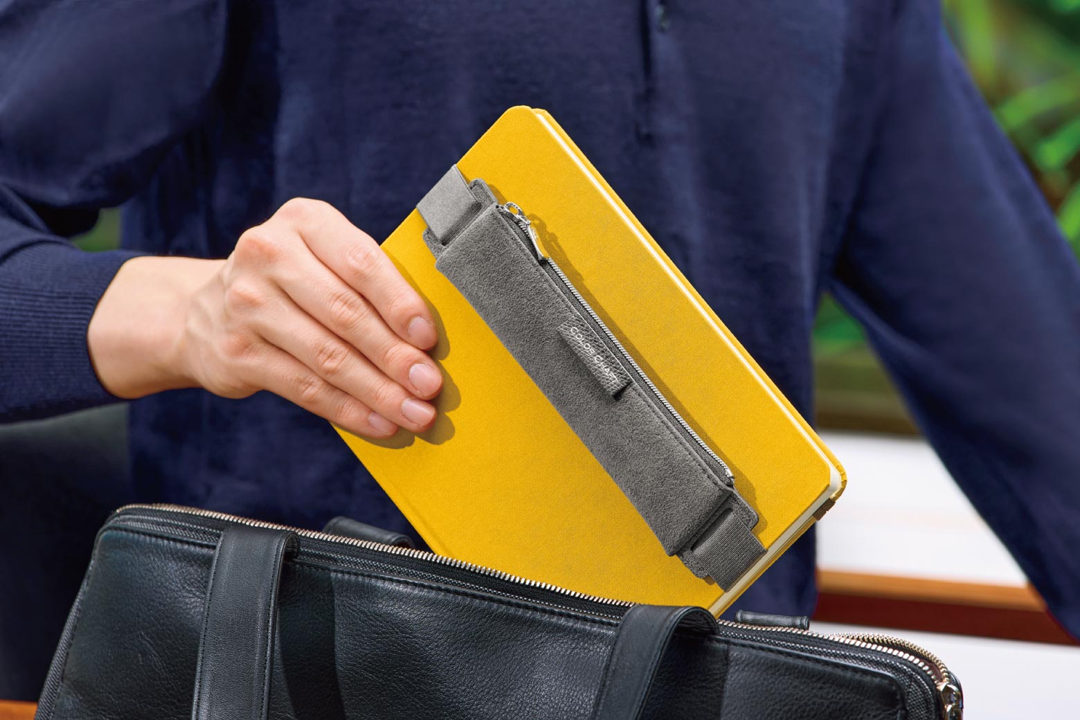 伊東屋　カラーチャート　バンド付きペンケース A5が付いたノートを鞄から取り出している様子