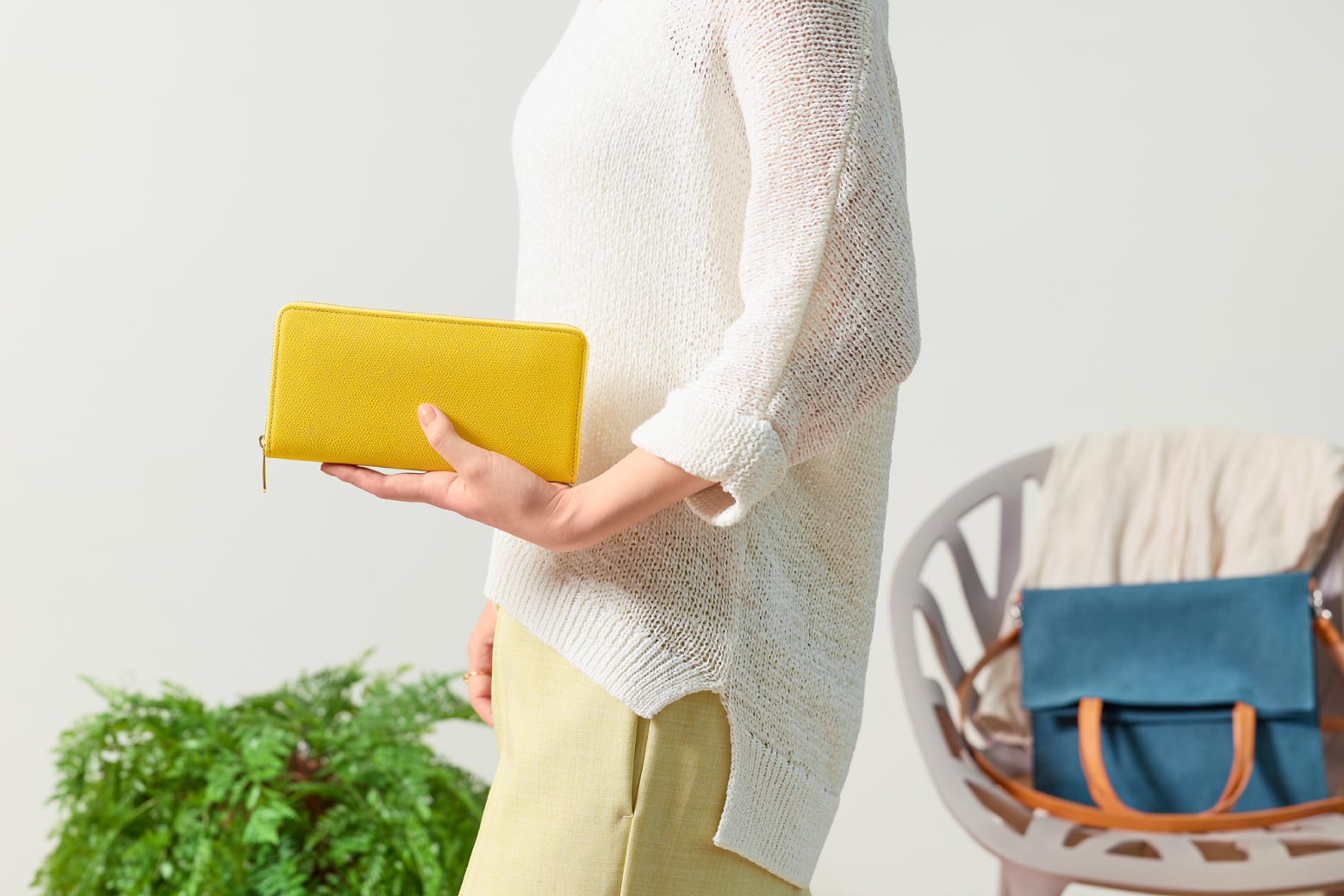伊東屋　カラーチャート　ジップウォレットロングをクラッチバッグのように抱えている様子